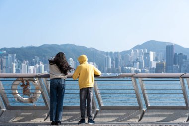 Hong Kong, Çin: 3 Ocak 2024: Yıldızlar Bulvarı 'nı ziyaret eden turistler. Yıldız Bulvarı, Hong Kong 'daki Victoria Limanı boyunca yer almaktadır. 