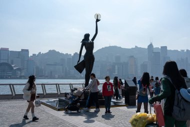 Hong Kong, Çin: 3 Ocak 2024: Yıldızlar Bulvarı 'nı ziyaret eden turistler. Yıldız Bulvarı, Hong Kong 'daki Victoria Limanı boyunca yer almaktadır. 