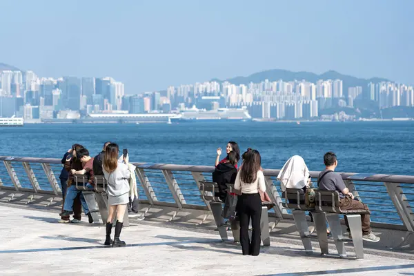 Hong Kong, Çin: 3 Ocak 2024: Yıldızlar Bulvarı 'nı ziyaret eden turistler. Yıldız Bulvarı, Hong Kong 'daki Victoria Limanı boyunca yer almaktadır. 