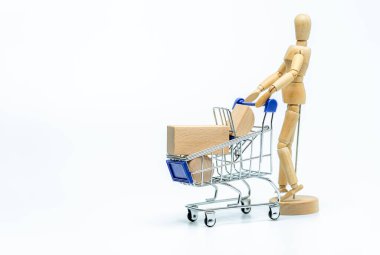 Beyaz arka planda alışveriş arabası olan tahta bebek. iş veya yaratıcı konsept