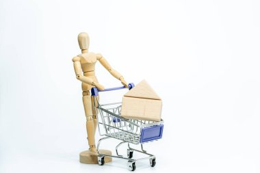 Beyaz arka planda alışveriş arabası olan tahta bebek. iş veya yaratıcı konsept