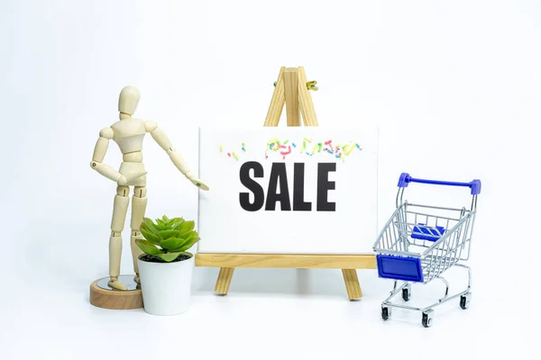 Mannequin drawing a SALE on easel; isolated on white background; Business or sales promotion concept