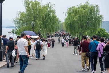 07 Mayıs 2024, Hangzhou, Çin: Batı gölünde yürüyen yayalar. Batı Gölü Hangzhou 'nun merkezinde bulunan ünlü bir tatlı su gölüdür.