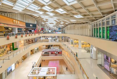 Hangzhou, Çin, 3 Haziran 2024: İnsanlar modern bir alışveriş merkezinde yürüyor