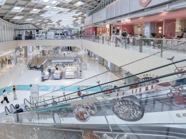 Hangzhou, Çin, 3 Haziran 2024: İnsanlar modern bir alışveriş merkezinde yürüyor