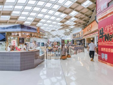 Hangzhou, Çin, 3 Haziran 2024: İnsanlar modern bir alışveriş merkezinde yürüyor