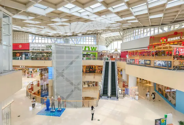Hangzhou, Çin, 3 Haziran 2024: İnsanlar modern bir alışveriş merkezinde yürüyor