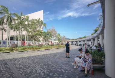 Tsim Sha Tsui, Hong Kong, Temmuz 2024: Turistler fotoğraf çekiyorlar ve Victoria Limanı boyunca uzanan ünlü Hong Kong adasının keyfini çıkarıyorlar 