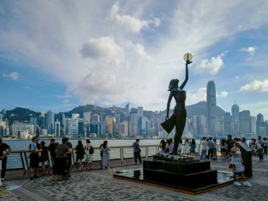 Tsim Sha Tsui, Hong Kong, Temmuz 2024: Turistler fotoğraf çekiyorlar ve Victoria Limanı boyunca uzanan ünlü Hong Kong adasının keyfini çıkarıyorlar 