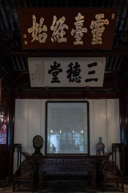 Şangay, Çin - Haziran 06, 2024: Karmaşık ahşap mobilyalar ve süslü el yazmaları Şangay, Yu Garden 'da bir odayı süslüyor. Geleneksel Çin dekoru tarih ve sükuneti çağrıştırıyor..