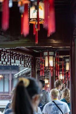 Şangay, Çin - Haziran 06, 2024: Geleneksel Çin fenerleri Yu Garden, Şangay 'daki bir koridorun tavanında asılı. Turistler geçitte yürüyor, bahçelerin güzelliğinin tadını çıkarıyorlar..