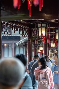 Şangay, Çin - Haziran 06, 2024: Şangay, Çin 'de Yu Garden' da turistler geziniyor. Kırmızı fenerler ve karmaşık ahşap işçiliği geçidi süslüyor..