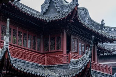 Şangay, Çin - Haziran 06, 2024: Yu Garden, Şangay 'daki geleneksel bir Çin binasının süslü çatı hattına yakın çekim. Karmaşık detaylar ve katmanlı çatılar antik Çin mimarisinin göz kamaştırıcı bir örneğini oluşturuyor..