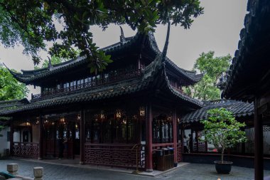 Şangay, Çin - Haziran 06, 2024: Yu Garden, Şangay 'daki geleneksel Çin mimarisi. Avlu bereketli yeşillik tarafından çerçevelenmiş, dingin bir atmosfer yaratıyor..