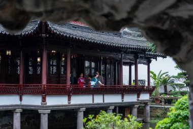 Şangay, Çin - Haziran 06, 2024: Yu Garden 'ın Şangay, Çin' deki görüntüsü. Kırmızı sütunları olan geleneksel bir pavyon yemyeşil bir gölün üzerinde duruyor..