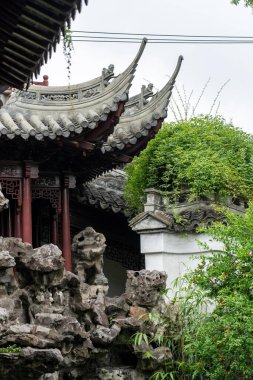 Şangay, Çin - Haziran 06, 2024: Yu Garden, Şangay, Çin 'deki geleneksel Çin binasının kıvrımlı çatıları, yemyeşil alanlar arasında.