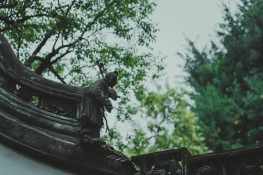 Şangay, Çin - Haziran 06, 2024: Çin 'in Şangay kentindeki Yu Garden' da karmaşık taş işçiliğine yakın plan. Verimli yeşillik ayrıntılı oymalar için bir zemin sağlar.