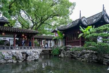 Şangay, Çin - Haziran 06, 2024: Yu Garden, Şangay, Çin 'de geleneksel Çin mimarisi ve yemyeşil ile çevrili sakin bir gölet.