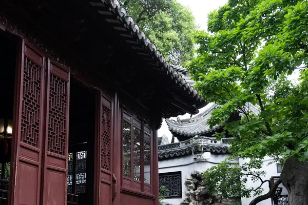 Şangay, Çin - Haziran 06, 2024: Yu Garden 'ın Şangay, Çin' deki karmaşık ayrıntılarına bir göz atma. Karmaşık ahşap pencereler ve geleneksel çatı çizgisi bahçenin güzelliğinin tadını çıkarıyor..