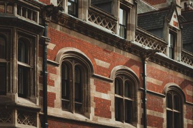 Cambridge, İngiltere 'de kemerli camları ve karmaşık taş işçiliği olan kırmızı tuğla bina..