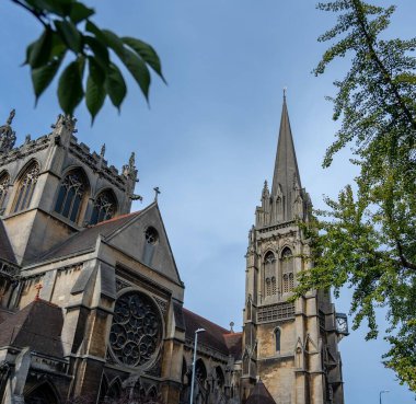 Cambridge, İngiltere - Ekim 08, 2023: Yüksek kulesi, yemyeşil çerçeveli karmaşık bir taş kilise, Cambridge, İngiltere 'de mavi bir gökyüzüne karşı duruyor..