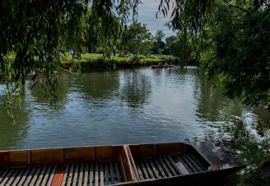 Cambridge, İngiltere - Ekim 08, 2023: 'Katherine' adında ahşap bir tekne Cambridge, İngiltere 'deki River Cam' de bulunuyor. Nehir sakin ve yansıtıcıdır. Yeşillik kıyıları doldurur..