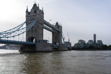 Londra, İngiltere - 09 Ekim 2023: Londra 'daki Tower Bridge manzarası, altında sakin bir nehir akıyor. Köprü uzaktan görülüyor..