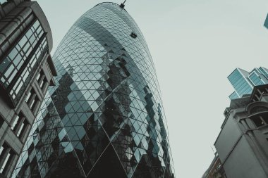 Londra, İngiltere 'de bulutlu gökyüzüne uzanan modern bir cam gökdelen..