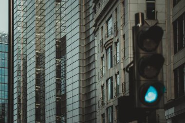 Londra, İngiltere 'de yeşil ışığı olan bir trafik ışığı. Işık modern ofis binalarının önünde..