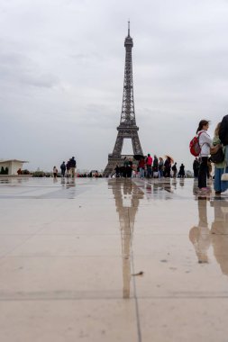 Paris, Fransa - 18 Ekim 2023: Paris, Fransa 'daki Eyfel Kulesi manzarası, ıslak bir kaldırım taşı meydanına yansıdı.