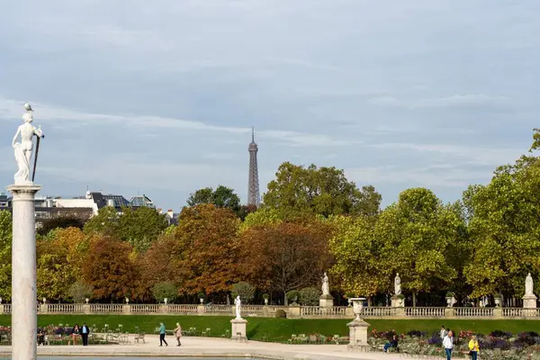 Paris, Fransa - 18 Ekim 2023: Bir Paris parkında bir heykel dikilir, ikonik kule uzaktan görülebilir.