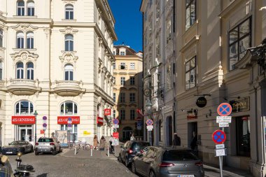 Wien, Avusturya - 28 Ekim 2023: Avusturya 'nın Viyana şehrinde tarihi binalarla dolu dar bir cadde. Arabalar yan tarafa park edilmiş ve insanlar oradan geçiyorlar..
