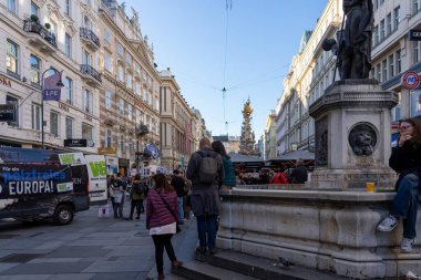 Wien, Avusturya - 28 Ekim 2023 Viyana, Avusturya 'da aslan başlı bir taş çeşme. İnsanlar kaldırımda yürür.