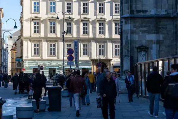 stock image Wien, Austria - October 28, 2023 : A busy street in Wien, Austria, with a large building in the background and people walking by.