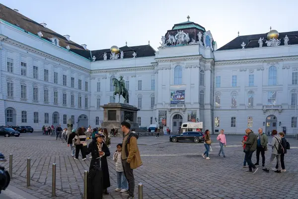 stock image Wien, Austria - October 28, 2023 : A large white building in Vienna, Austria, with a statue in front of it and people walking around.