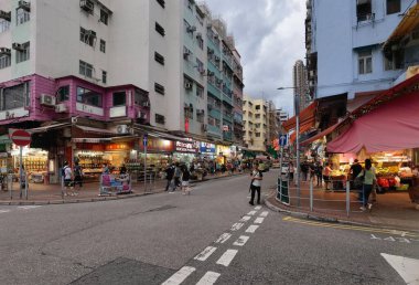 Hong Kong, Çin - 21 Temmuz 2024: Hong Kong, Çin 'de dükkan ve yayalarla dolu hareketli bir cadde. İki tarafında yüksek binalar olan cadde dardır..