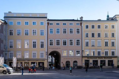 Salzburg, Avusturya - 01 Kasım 2023: Birkaç tarihi bina ve birkaç yayanın bulunduğu Salzburg, Avusturya 'da sakin bir sokak manzarası.