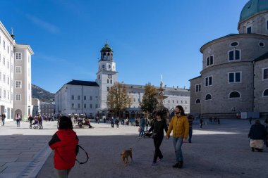 Salzburg, Avusturya - 01 Kasım 2023: Salzburg, Avusturya 'da bir meydan, ön planda bir çeşme ve arka planda yüksek binalar.