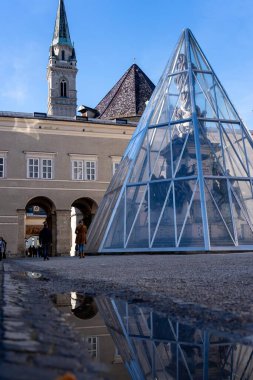 Salzburg, Avusturya - 01 Kasım 2023: Bir cam piramit Avusturya 'nın Salzburg kentinde bir heykeli kaplıyor.