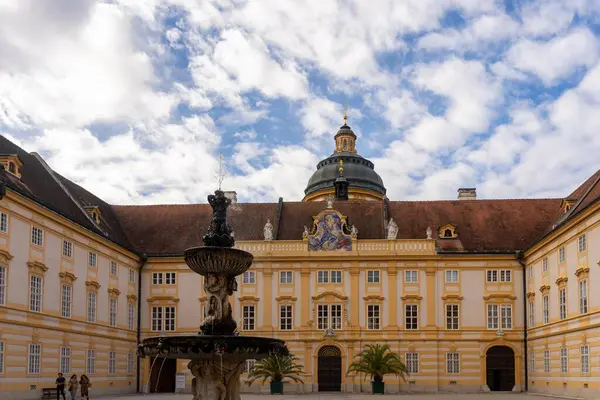 stock image Melk, Austria - October 25, 2023 : A fountain in the courtyard of a historic building in Melk, Austria, with a dome and a cross at the top.