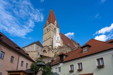 Vaçu, Avusturya - 26 Ekim 2023: Avusturya 'nın Wachau kentindeki güzel bir köyün çatısında saat yüzlü bir kilise kulesi yükseliyor.