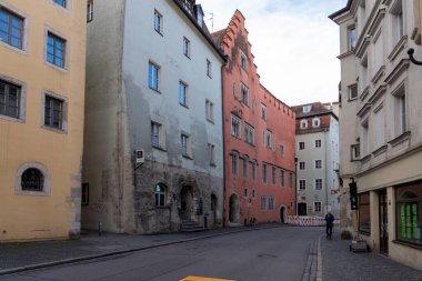 Regensburg, Almanya - 06 Kasım 2023: Regensburg, Almanya 'da renkli binalar ve yalnız yayalarla dolu bir kaldırım.