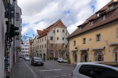 Regensburg, Almanya - 06 Kasım 2023: Regensburg, Almanya 'da tarihi binalarla dolu bir kaldırım taşı caddesi. Bir araba soldaki otelin önünden geçiyor..