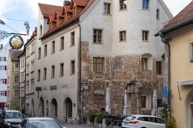 Regensburg, Almanya - 06 Kasım 2023: Almanya 'nın Regensburg şehrinde tarihi binalarla dolu dar bir cadde. Sokağa birkaç araba park edilmiş..