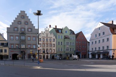 Regensburg, Almanya - 06 Kasım 2023: Renkli tarihi binalar ve birkaç kişinin geçtiği Regensburg, Almanya 'da bir sokak sahnesi.