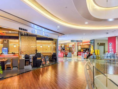 Shenzhen, Çin - 29 Temmuz 2024: Ahşap döşemeli ve eğimli tavanlı modern bir alışveriş merkezinde boş yemek salonu.