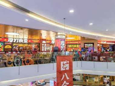 Shenzhen, Çin - 29 Temmuz 2024: Shenzhen, Çin 'deki bir alışveriş merkezinin üst katlarından bir manzara. Parlak tabelalı restoranlar alt katta..