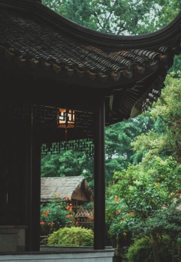 Tahta çerçevenin içinden bir Suzhou bahçesine bir göz atmak, sıcak bir ışık saçan tek bir fener..