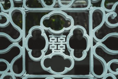 Geleneksel Çin bahçesinde karmaşık desenli beyaz kafes işi..