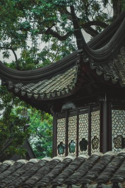 Suzhou, Çin 'de geleneksel bir Çin bahçe köşkü fayanslı çatısı ve dekoratif pencere tasarımları var..